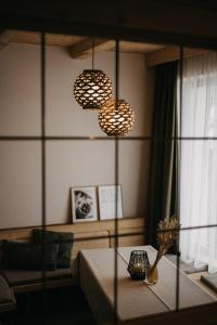 ein Wohnzimmer mit 2 Leuchten und einem Tisch in der Unterkunft FRÄULEIN NANNERL - Boutique Aparthotel in Gerlos
