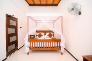 a bedroom with a bed with a mosquito net at Dream Villa - Tangalle in Tangalle