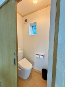 a bathroom with a toilet and a window at Snow Fever - Clique in Hakuba
