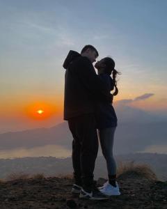 a man and woman kissing on top of a mountain at jeep sunrise and trakking in Kintamani