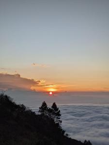a view of the sun rising over a sea of clouds at jeep sunrise and trakking in Kintamani