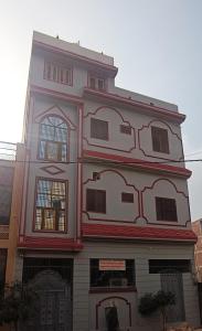 a large white building with windows on the side of it at Shastreey Sangeet Nivas in Vrindāvan