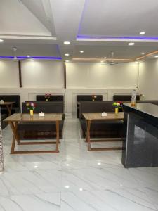 een restaurant met tafels en stoelen met bloemen erop bij Royalwood City Inn in Biratnagar