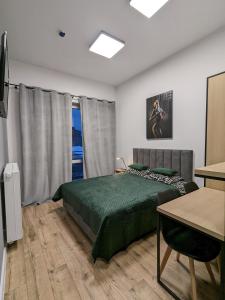 1 dormitorio con cama, mesa y ventana en Sleep & go A13 en Varsovia