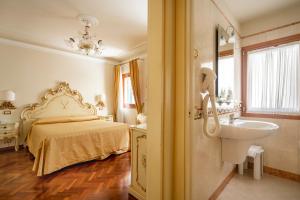 - une chambre avec un lit, un lavabo et un miroir dans l'établissement Locanda Al Leon, à Venise 37 autres photos