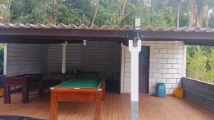 a ping pong table with a cell phone on a patio at CHÁCARA STA EDWIGES/ARUJA in Arujá