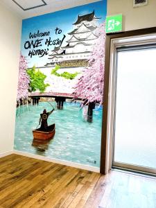 a wall mural of a woman in a boat in a river at ONE HOSTEL Himeji in Himeji