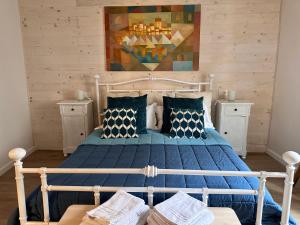 1 dormitorio con 1 cama con sábanas y almohadas azules en Amiter Bagni San Filippo, en Bagni San Filippo