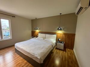 a bedroom with a large bed and two lights at West Port Hotel in Sihanoukville