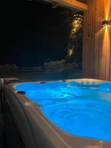 eine Whirlpool-Badewanne, die nachts beleuchtet ist in der Unterkunft Waldheimatblick in Sankt Kathrein am Hauenstein