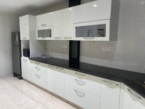 a kitchen with white cabinets and a black counter top at Villa by the Sea in Port Blair