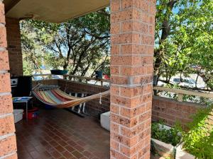 a porch with a hammock on a brick wall at A private room in a homestay!! in Bankstown