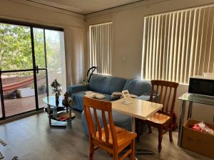 uma sala de estar com um sofá azul e uma mesa em A private room in a homestay!! em Bankstown