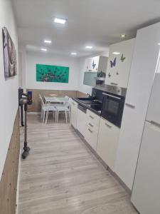 a kitchen with white cabinets and a dining table at MAISON CLIMATISEE ,2 CHAMBRES, PARKING compris in La Ciotat
