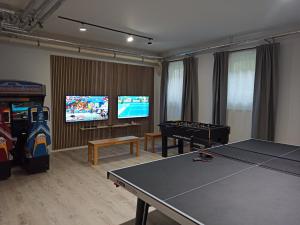 a living room with a ping pong table and a tv at Hotel Nummerhof in Erding