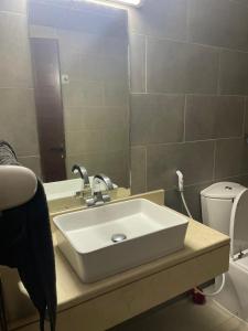 a bathroom with a sink and a toilet and a mirror at Heart of Abu Dhabi - Elite Community in Abu Dhabi