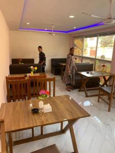 twee personen in een kamer met tafels en stoelen bij Royalwood City Inn in Biratnagar