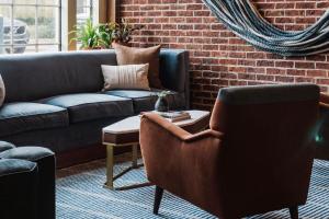 a living room with a couch and a chair at The Alida, Savannah, a Tribute Portfolio Hotel in Savannah