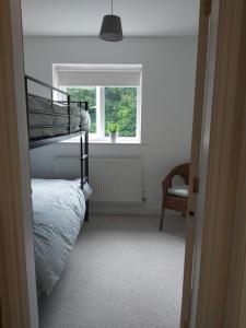 a bedroom with a bunk bed and a window at Peaceful marina-side house in north Wales in Caernarfon
