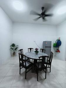 a dining room table and chairs with a ceiling fan at Kuantan Nadira Suite Homestay in Kuantan