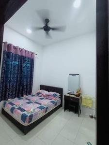 Schlafzimmer mit einem Bett, einer Kommode und einem Spiegel in der Unterkunft Kuantan Nadira Suite Homestay in Kuantan