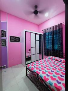 ein Schlafzimmer mit einem Bett in einem rosa Zimmer in der Unterkunft Kuantan Nadira Suite Homestay in Kuantan