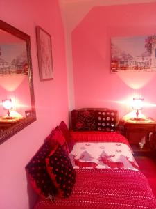 a bedroom with pink walls and a bed and two lamps at Guest House Cinderella in Herceg-Novi