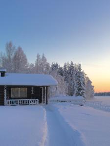a house covered in snow with a driveway at Kätkä Lake Lodge in Tervola