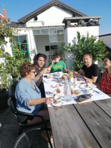 um grupo de pessoas sentadas à volta de uma mesa a comer em The Liberty Terrace em Udine