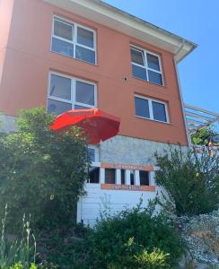 a red umbrella in front of a building at Ferienwohnung Drachennest mit Sonnenterrasse in Feldkirch