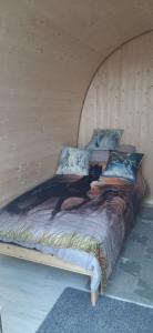 a bed in a room with a wooden wall at "PONY POD" at Nelson Park Riding Centre Ltd in Kent