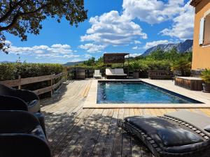 - une piscine sur une terrasse en bois avec des montagnes en arrière-plan dans l'établissement Maison d'hôtes la Garenne, à Puyloubier