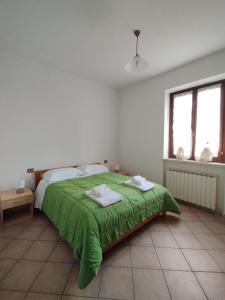 una camera da letto con un letto verde con due asciugamani di Azienda Agricola Baldini Ferdinando a Montaperti