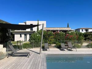 a patio with chairs and a pool and a building at Villa U Sanda in Lecci