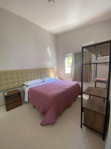 Un dormitorio con una cama grande y una ventana en Apartamento em condomínio de luxo próximo à praia, en Porto Seguro