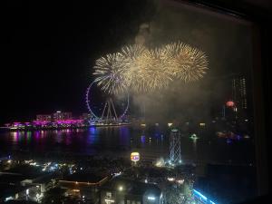 a fireworks display at night with a ferris wheel in the background at Usmans 4BDRM APARTMENT SEA VIEW Rimal in Dubai