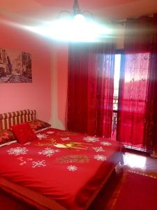 a bedroom with a red bed with red curtains at Guest House Cinderella in Herceg-Novi