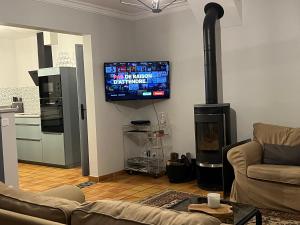 a living room with a fireplace and a flat screen tv at Gite Chez Léa in Saint-Brieuc-de-Mauron