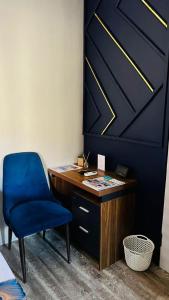 a desk and a blue chair in a room at Shiloh Inn in Gaborone