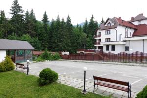a parking lot with two benches and a tennis court at GO GO RILA PARK in Borovets