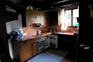 una pequeña cocina con armarios de madera y una ventana en Rustico Storelli, en Brissago