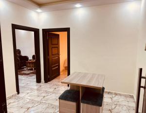 um quarto com uma mesa de madeira e uma porta em Dream Hotel jerash em Gérasa
