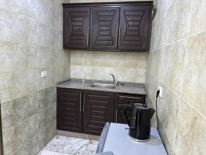 uma cozinha com armários castanhos e um lavatório em Dream Hotel jerash em Gérasa
