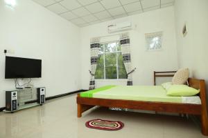 una camera con letto e TV a schermo piatto di Lovely 2 Bedroom Apartment (With Bathroom& Kitchen) a Anuradhapura