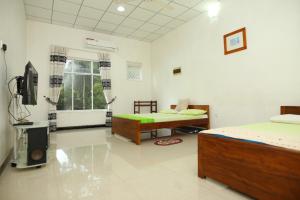 una camera con due letti e una televisione in esso di Lovely 2 Bedroom Apartment (With Bathroom& Kitchen) a Anuradhapura