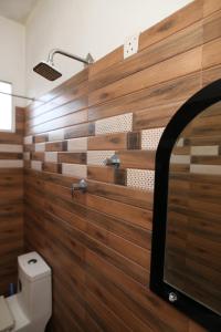 een badkamer met houten wanden en een toilet bij Lovely 2 Bedroom Apartment (With Bathroom& Kitchen) in Anuradhapura