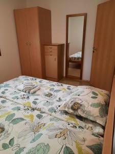 a bedroom with a bed with a floral bedspread at APARTMA SABOTIČ in Sedula