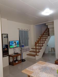 a living room with a staircase and a table at Cebu City 80sq Apartment near SM Seaside NuStar Ocean Park Dynamic Herb in San Roque