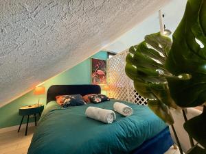a bedroom with a bed with pillows and a plant at -Tropical Studio- Paisible Parking Wifi Lave-Linge in Quimper