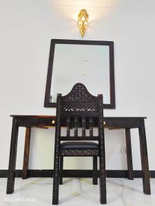 um espelho em cima de uma secretária de madeira com uma cadeira em Ayaa Luxury Apartment 4th Floor Zanzibar em Zanzibar